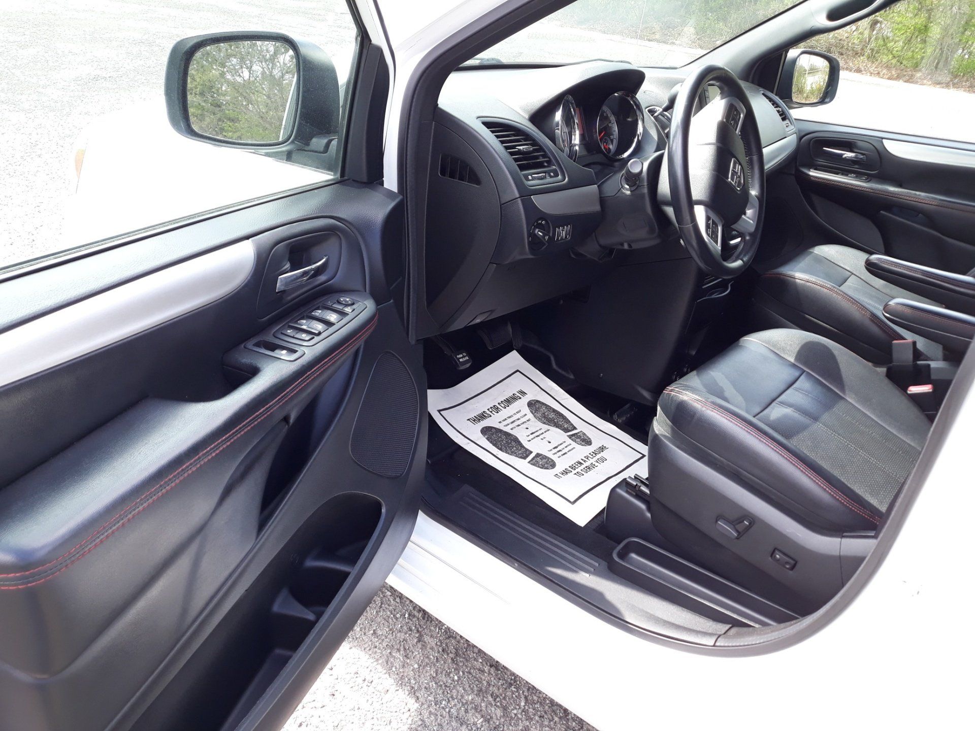 The inside of a white car with the door open