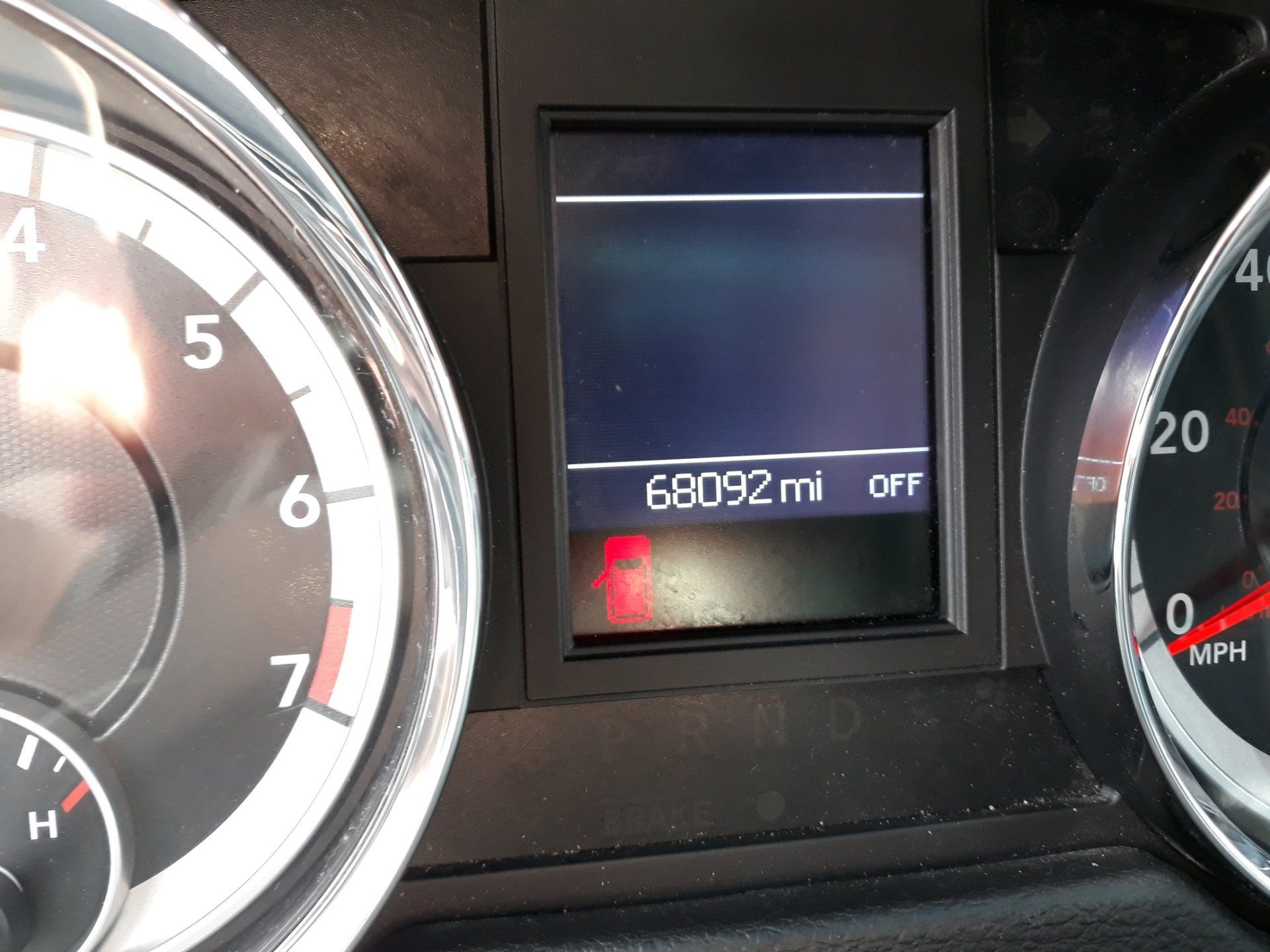 A close up of a car dashboard with a screen that says 60902 miles