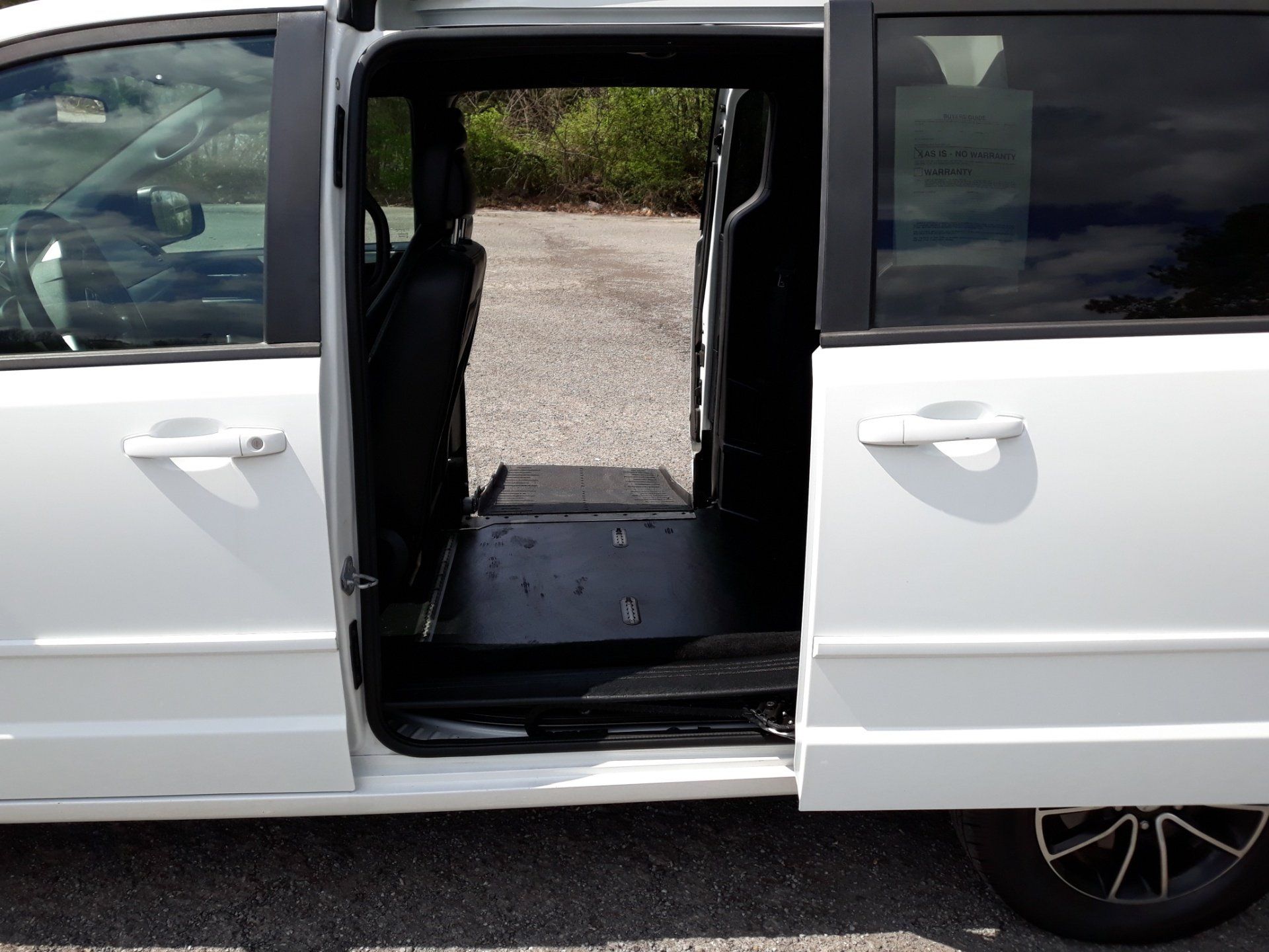 A white van with the doors open and the trunk open