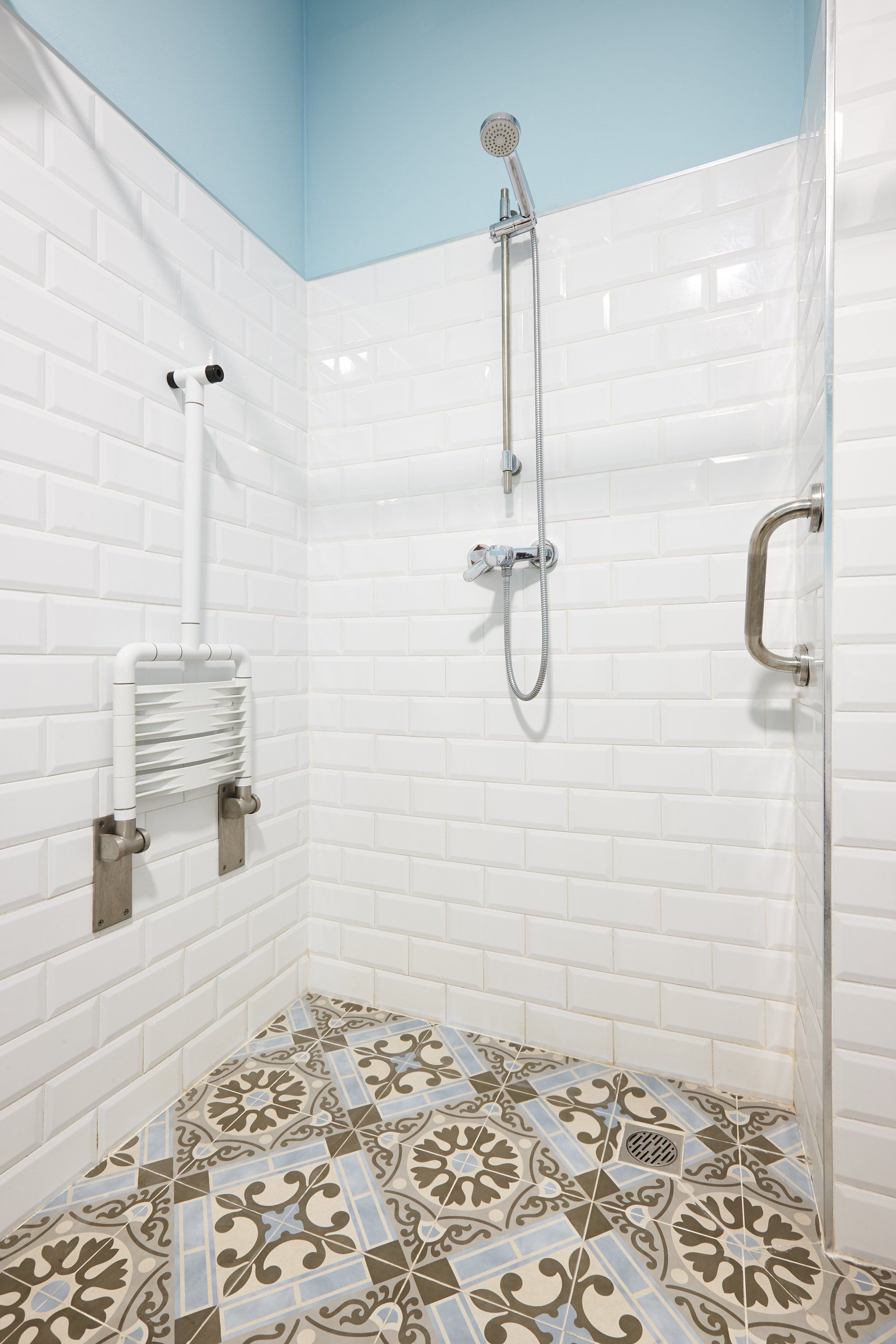 A bathroom with a walk in shower and a tiled floor.