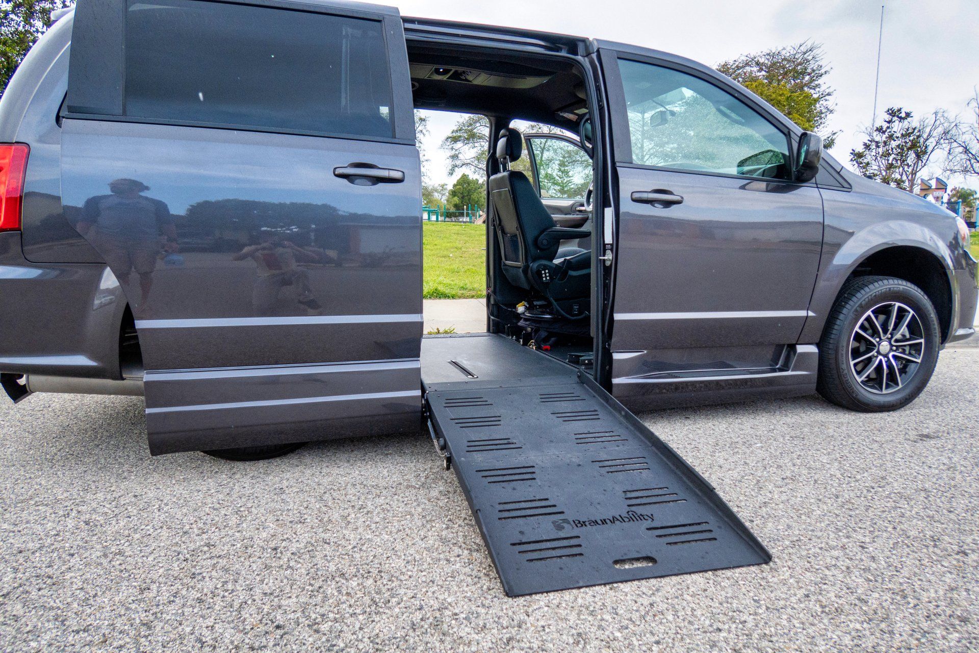 A handicapped van with its doors open and a ramp.