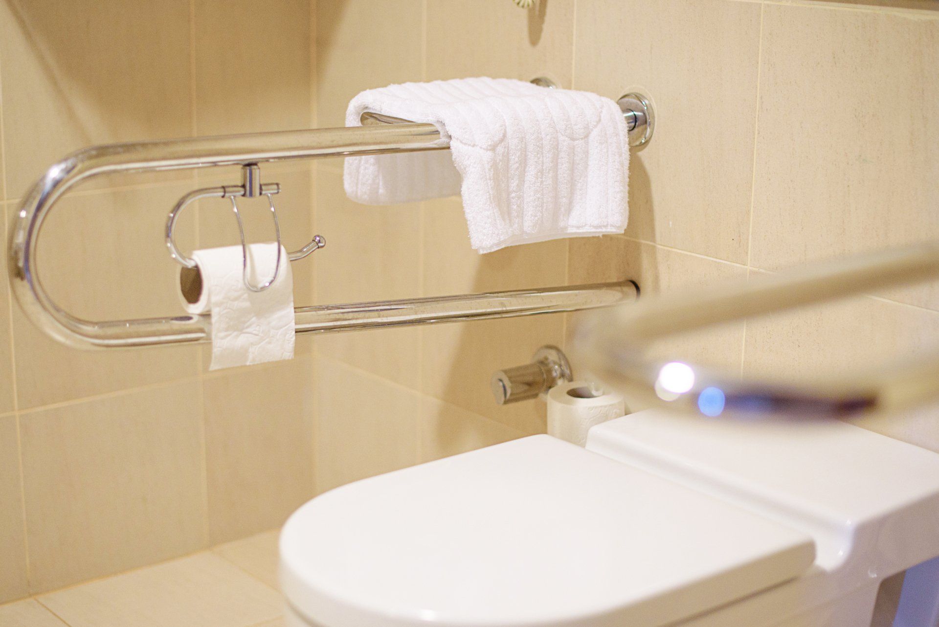 A bathroom with a toilet and a towel rack.