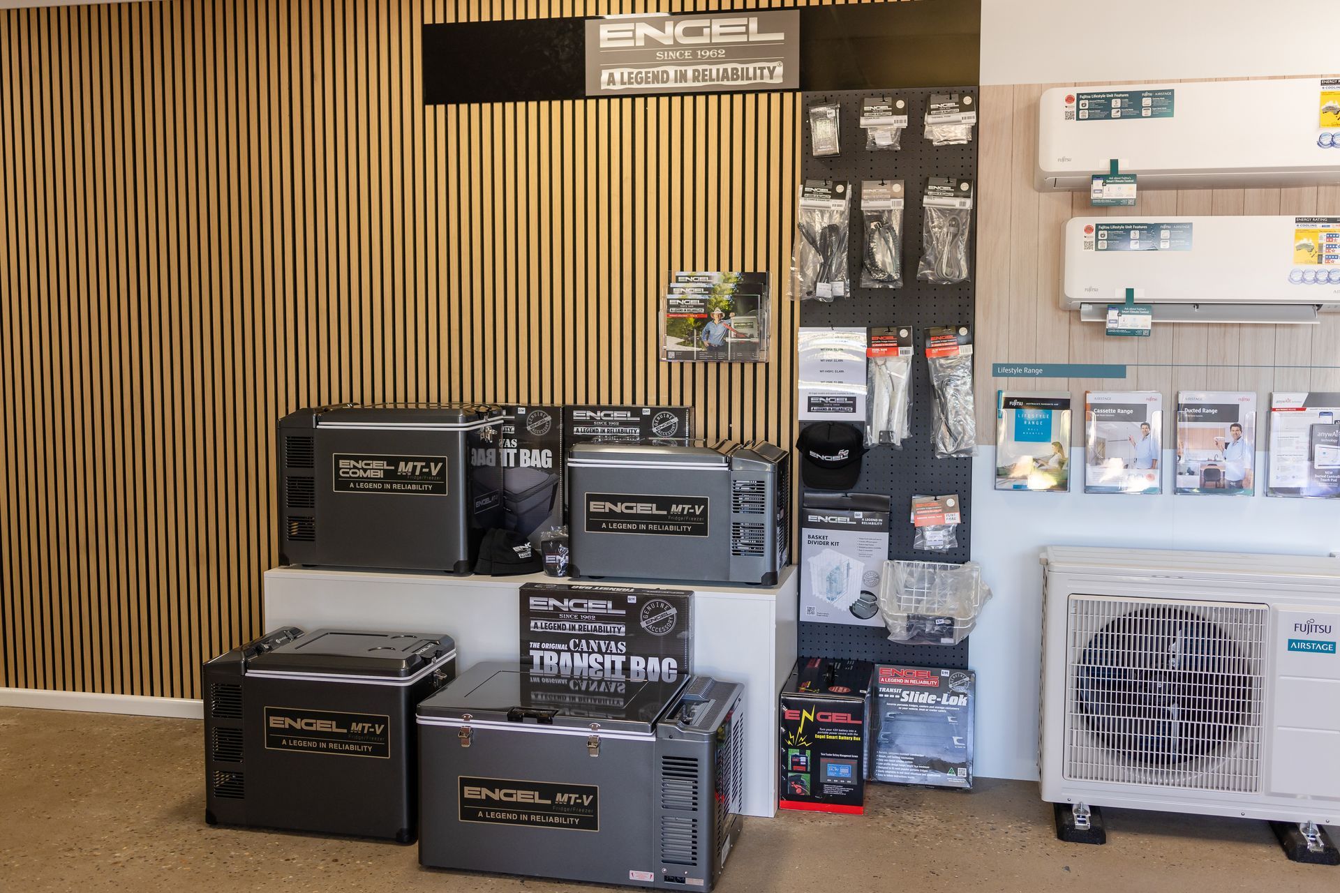 A showroom filled with a variety of refrigerators and air conditioners.