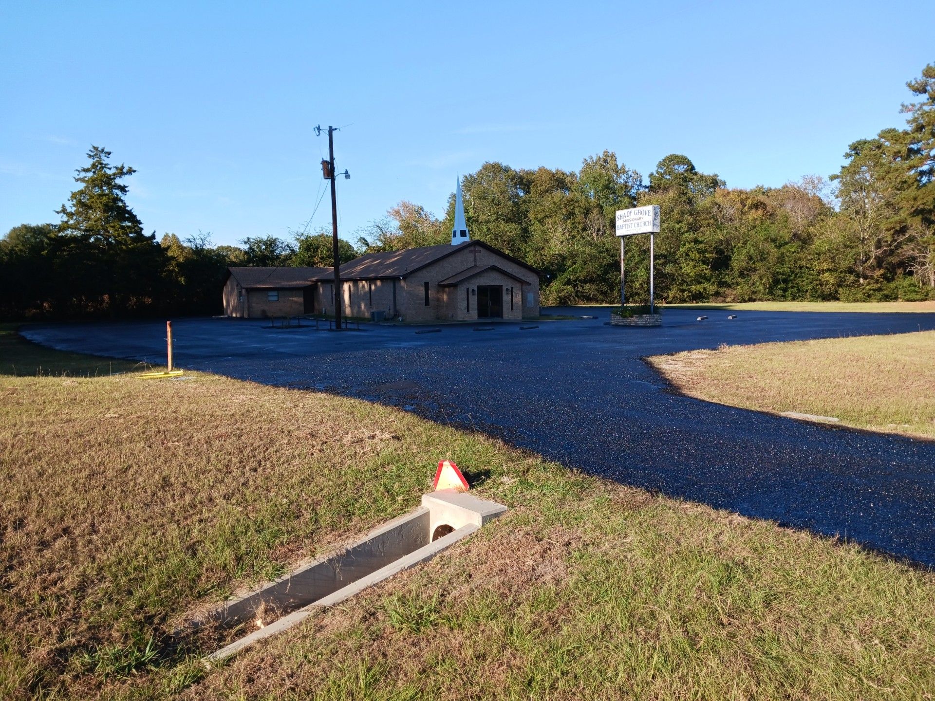 A small house sits in the middle of a grassy field