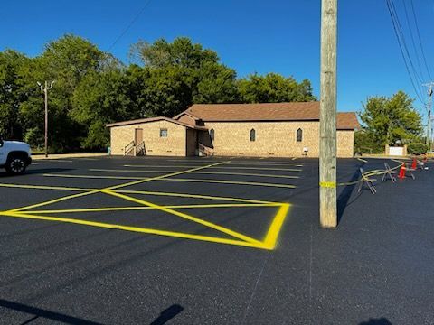 A white truck is parked in a parking lot in front of a brick building