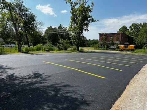 A parking lot with yellow lines and trees in the background