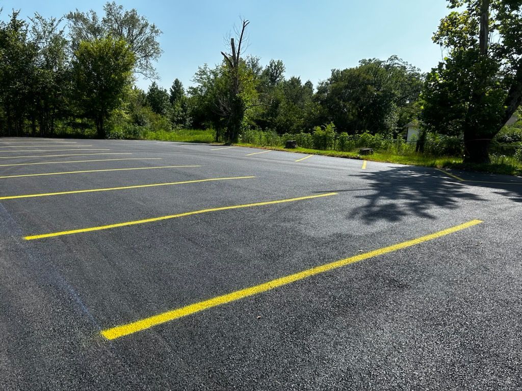 A parking lot with yellow lines on it and trees in the background