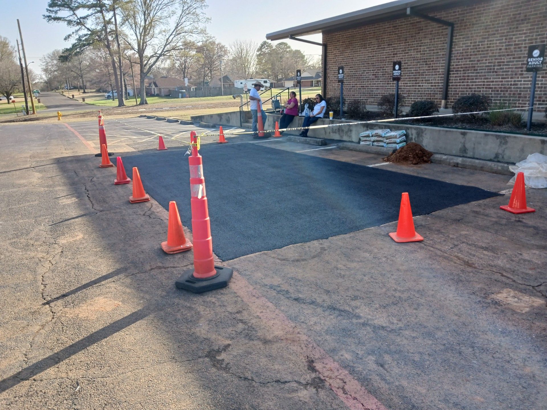 A group of orange cones are sitting on the side of a road