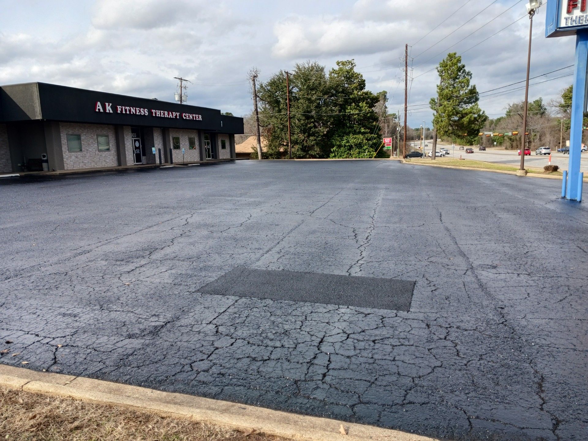 An empty parking lot with a building in the background