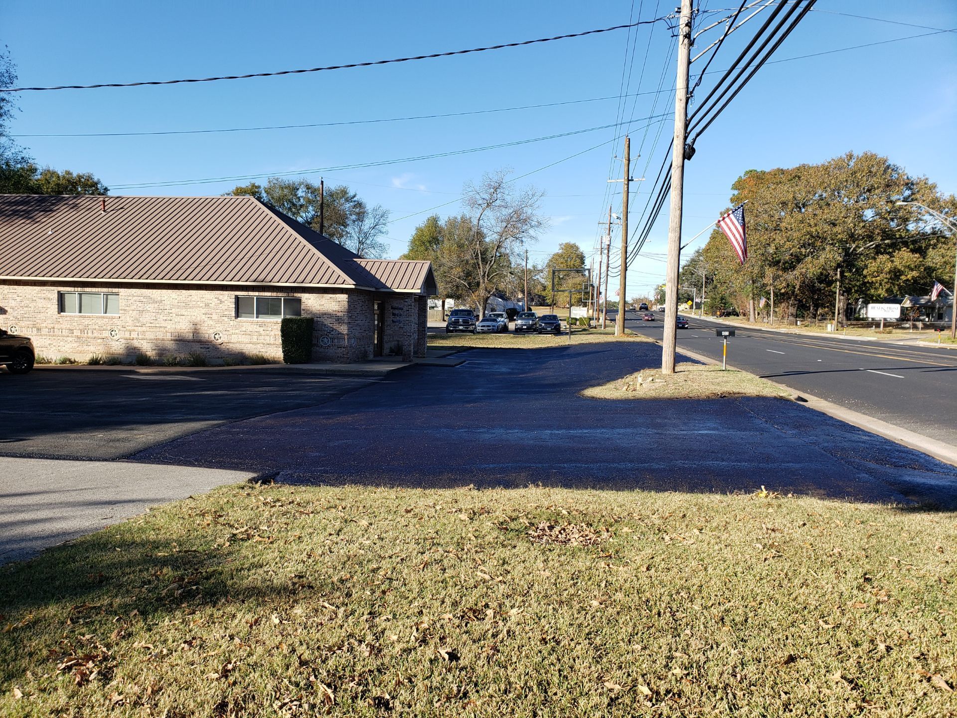 A house is sitting on the corner of a street next to a road.