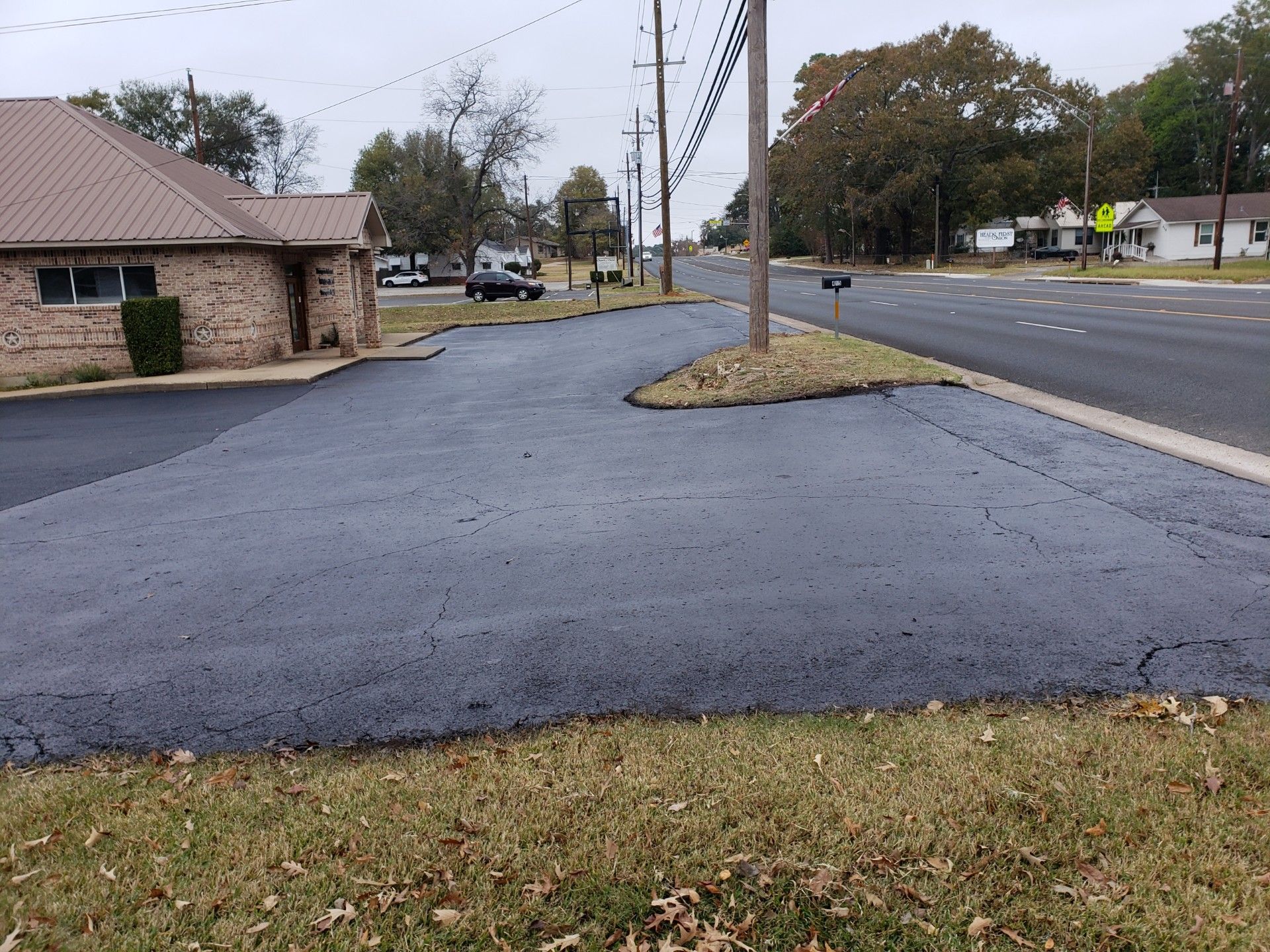 A parking lot with a brick building in the background