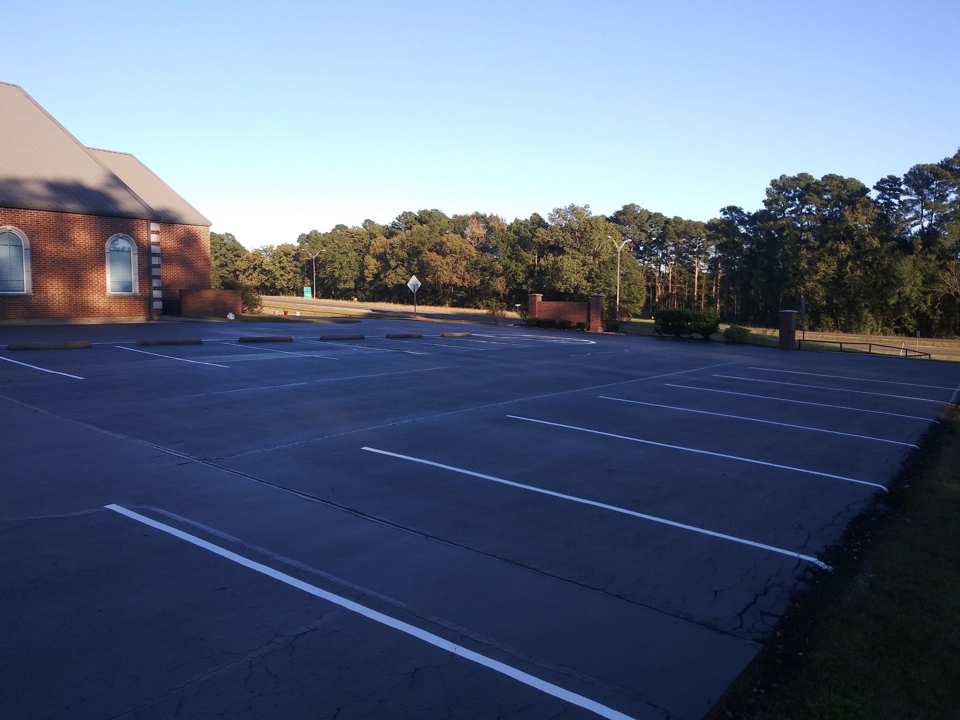 A parking lot with a brick building in the background