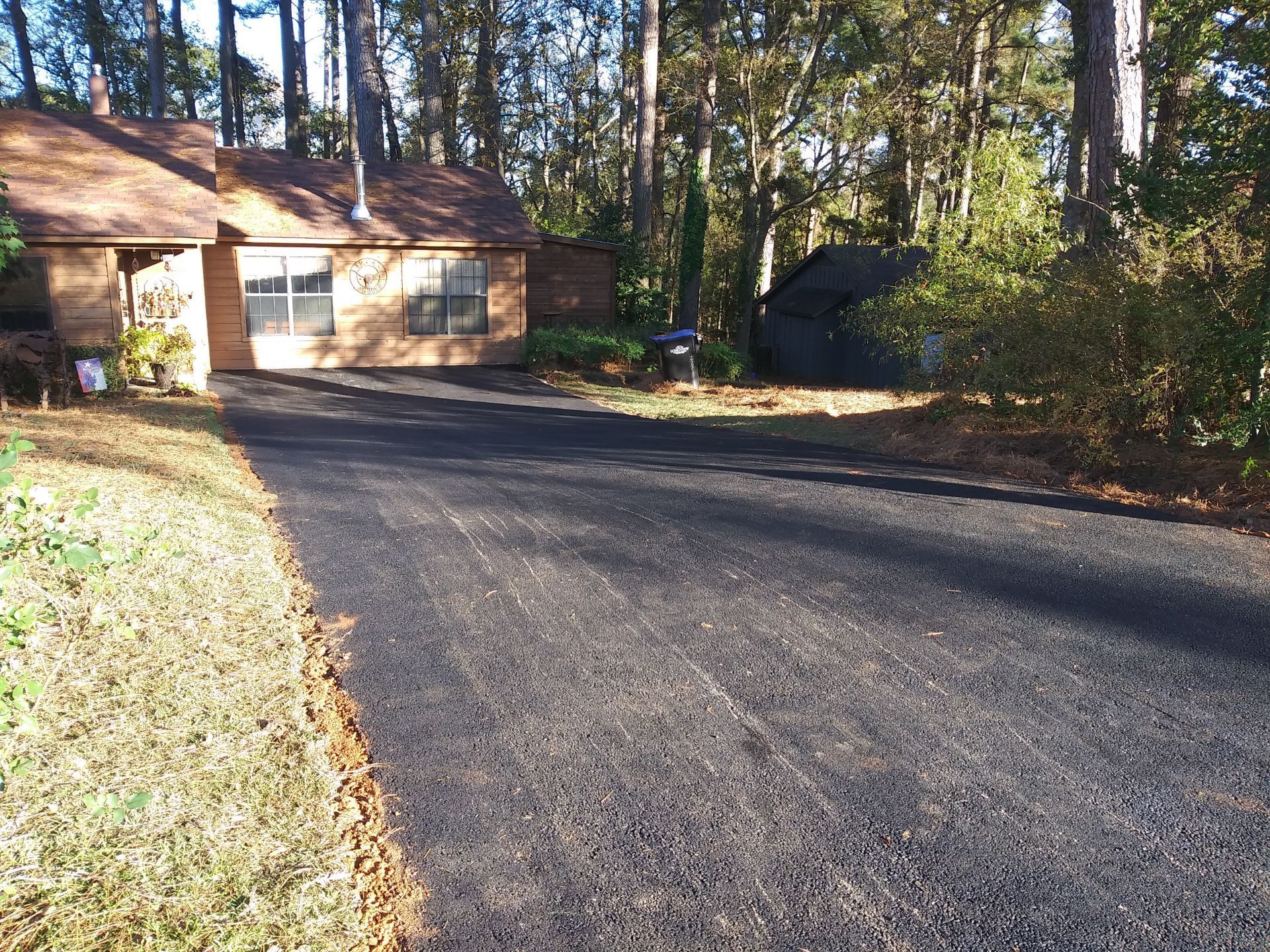 A driveway leading to a house in the woods