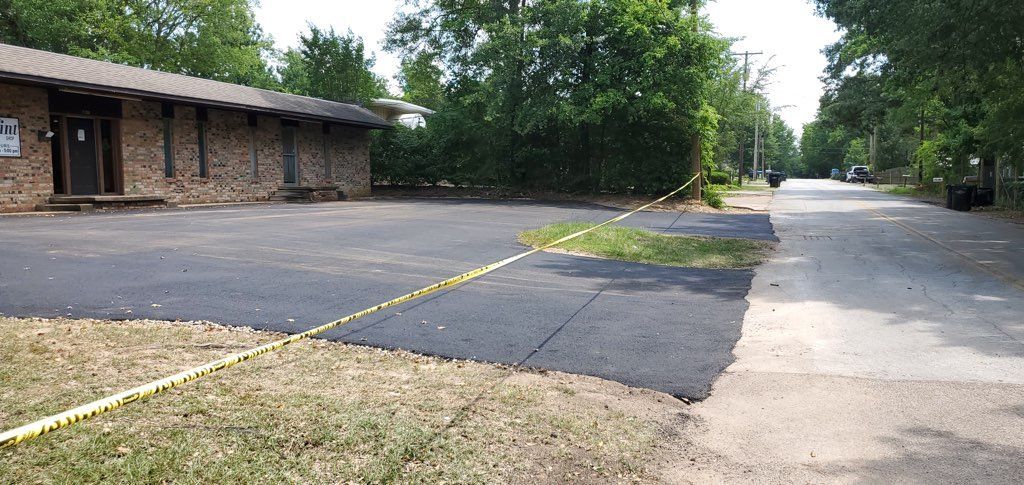 An empty parking lot with a building in the background
