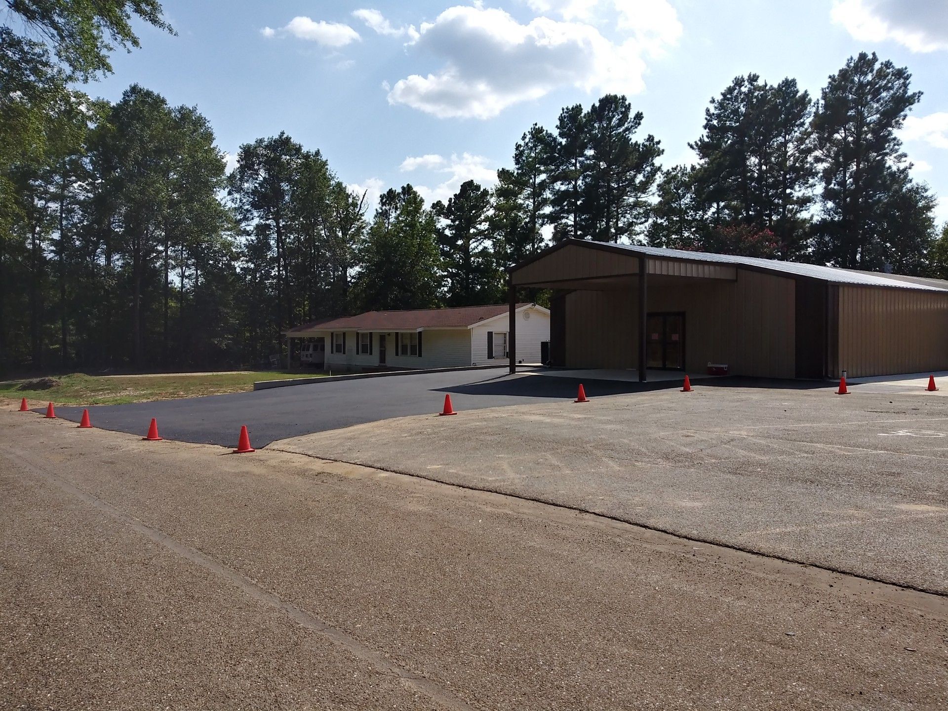 A parking lot with red cones and a building in the background
