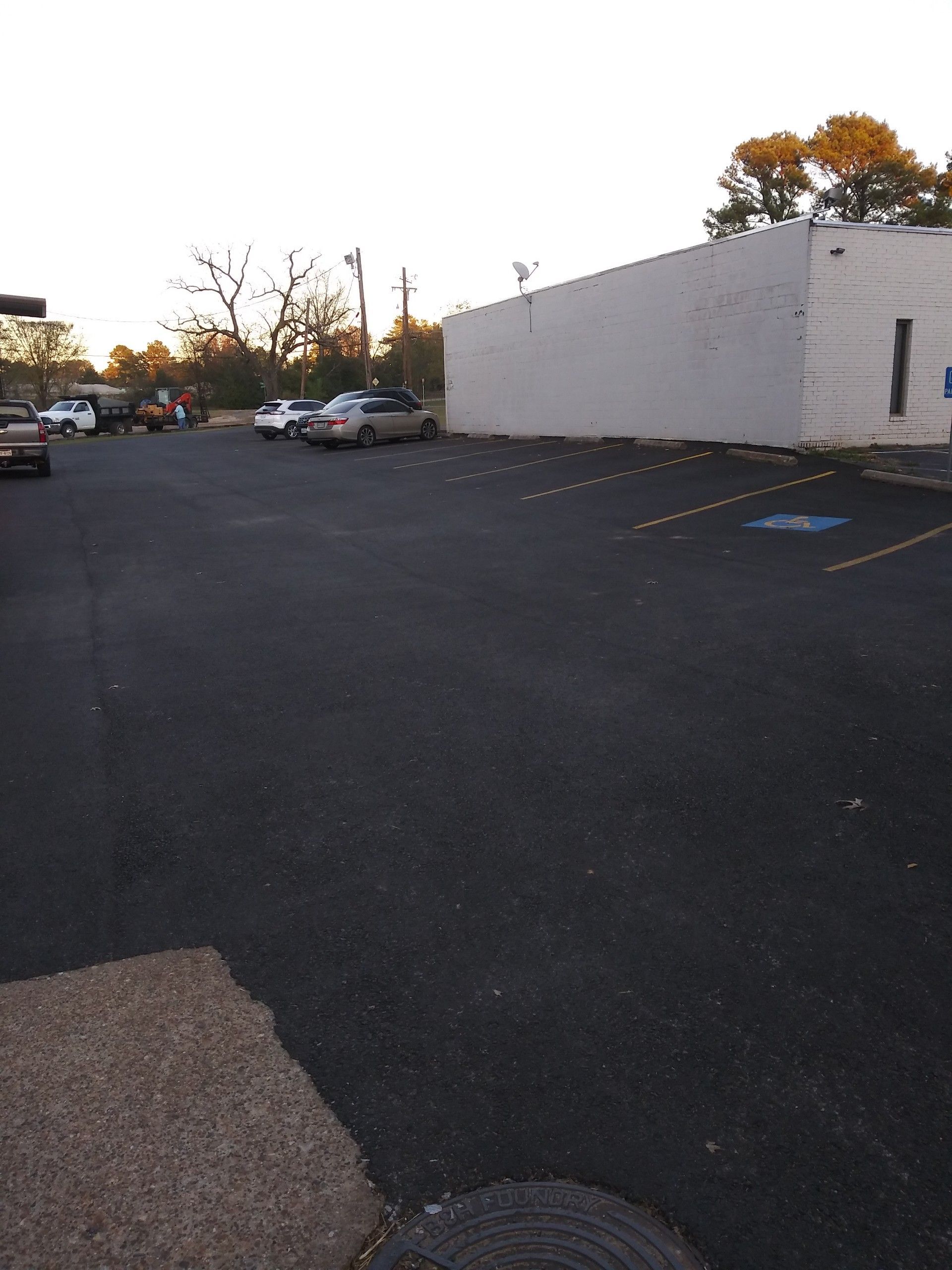 A parking lot with a white building in the background