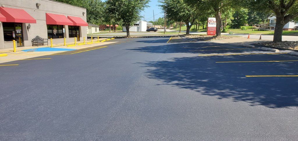 A parking lot in front of a building with red awnings