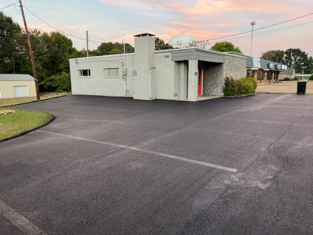 A parking lot with a white building in the background