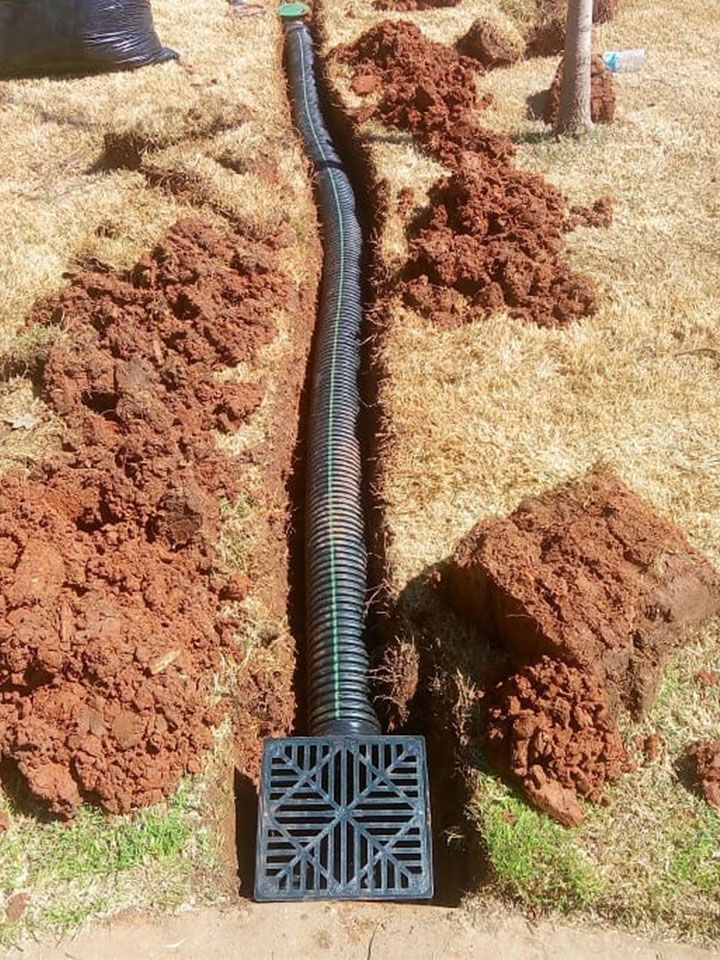 A Drain Pipe is Being Installed in the Dirt in a Yard