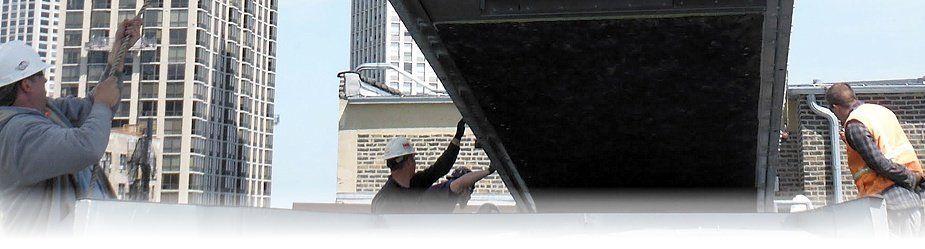 Construction workers on a roof, working on a structure, city buildings in the background.