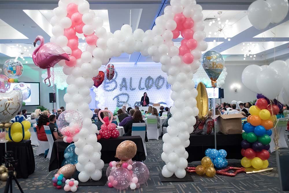 White balloon arch with white and pink Ears attached to the top