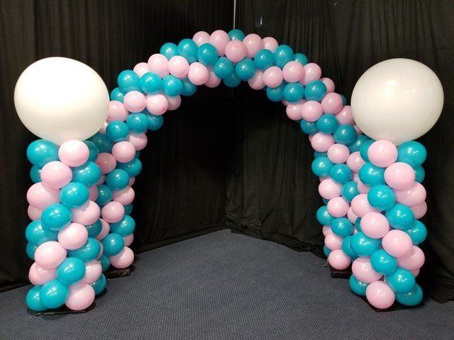 oink and teal balloon arch with two matching balloon columns