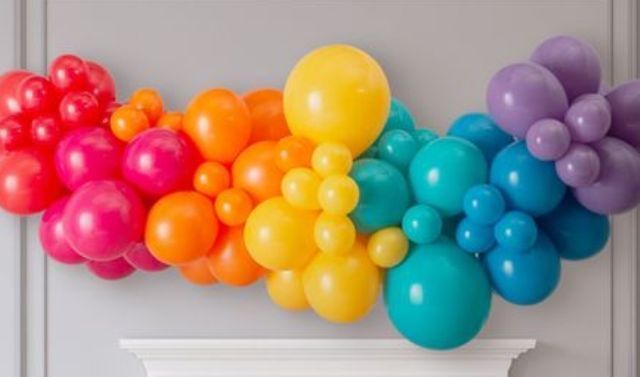 rainbow colored balloon garland on wall