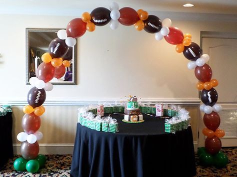 linking balloons shaped like footballs to create an arch
