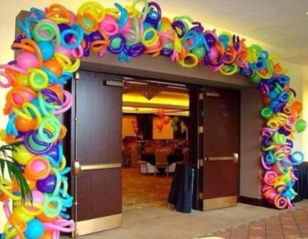multicolored balloon arch with curly balloons added