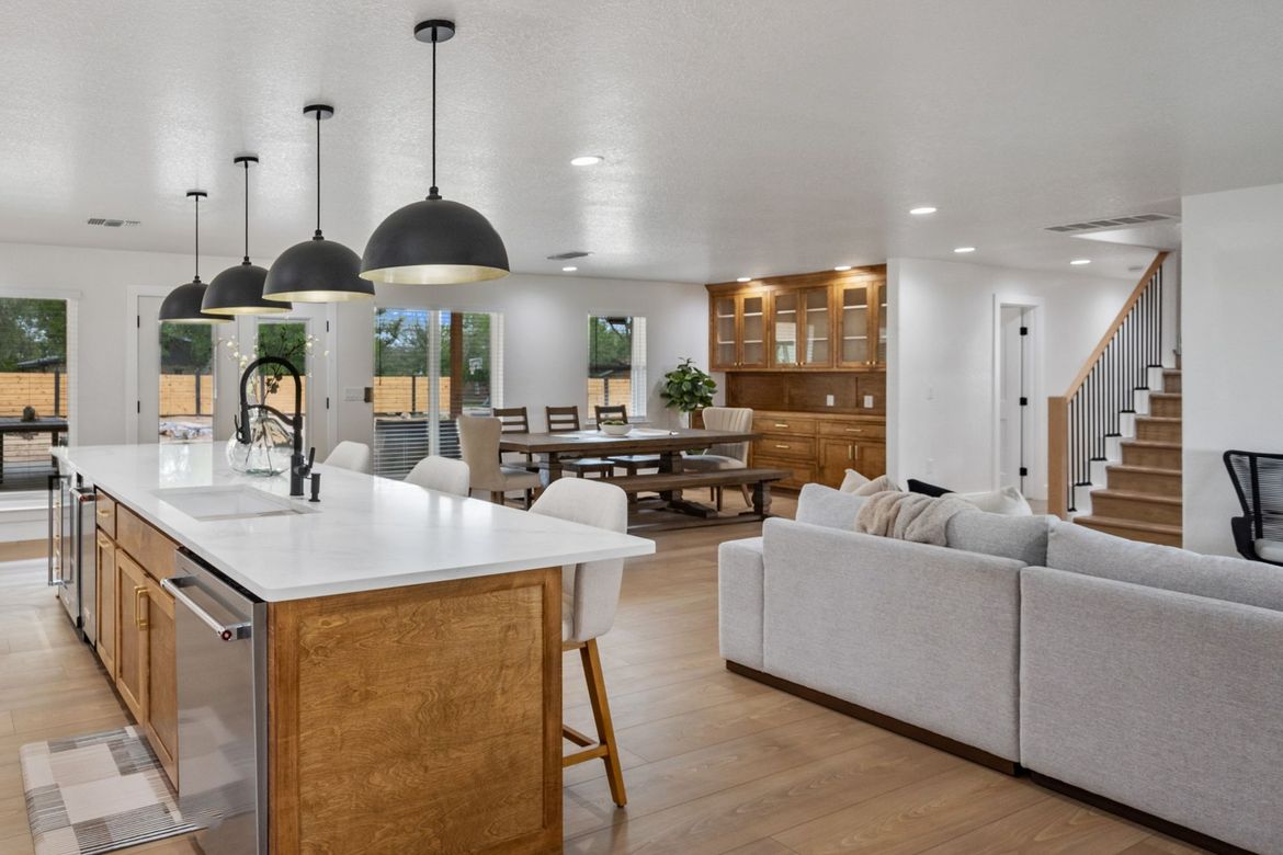 A kitchen with a large island and a couch in a living room.