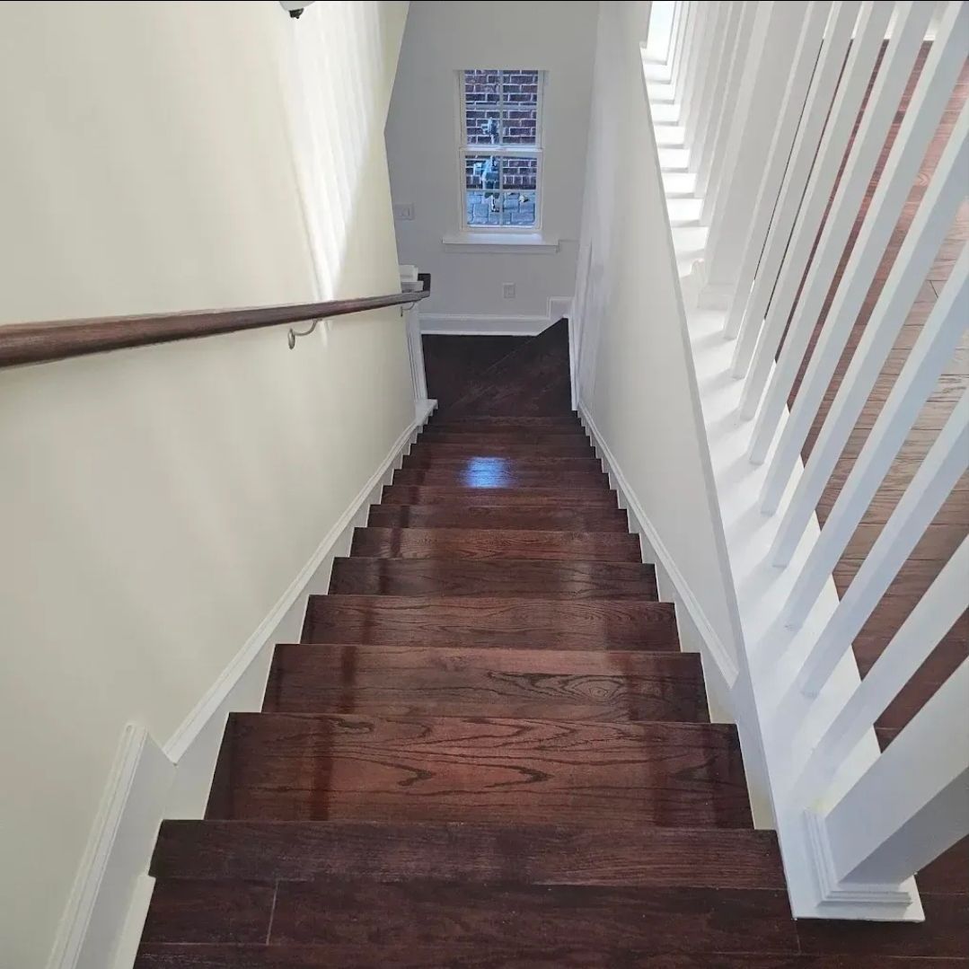 Demolished shed with a Bobcat loader on a grassy field under a cloudy sky.