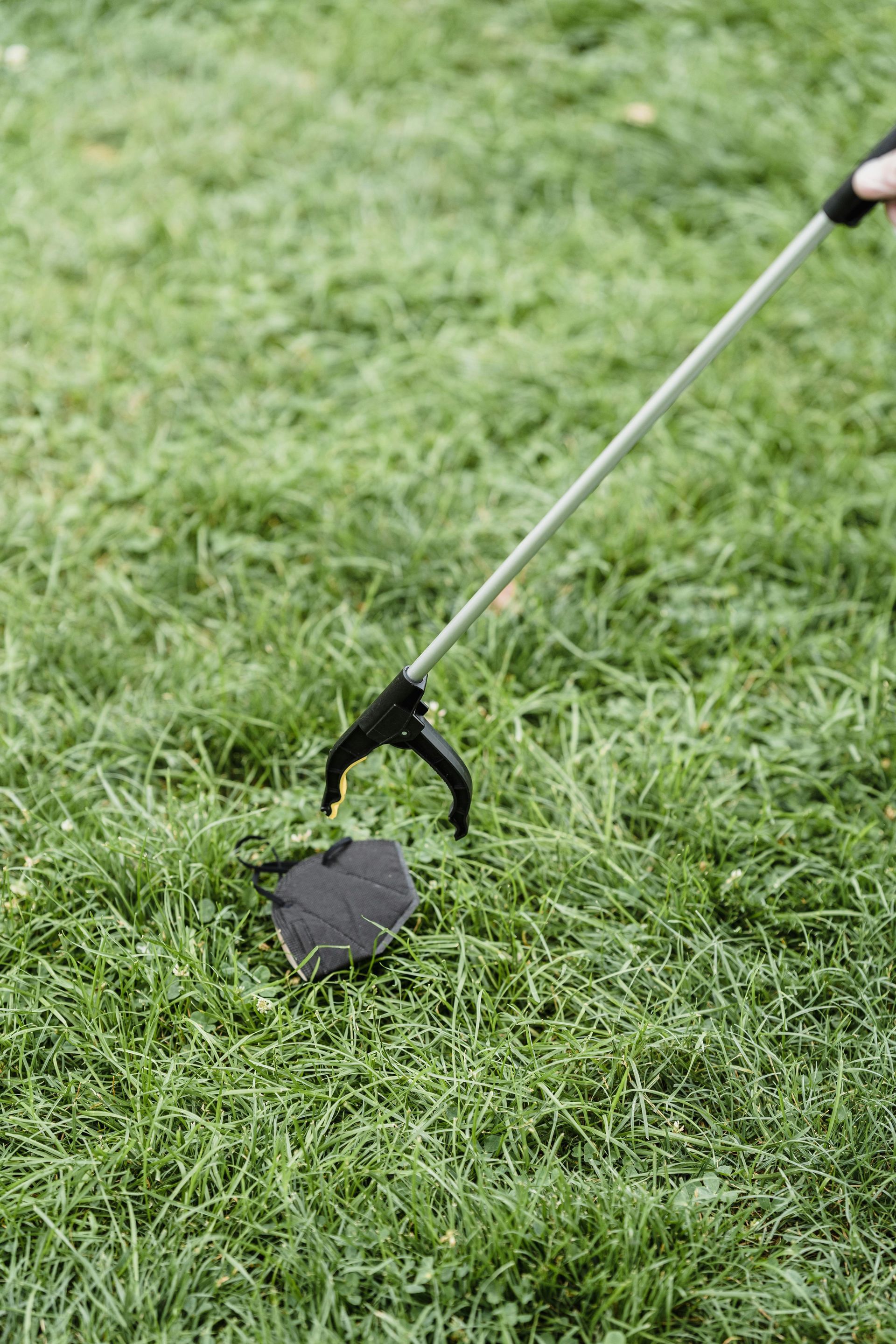 A shovel is sitting on top of a lush green lawn.