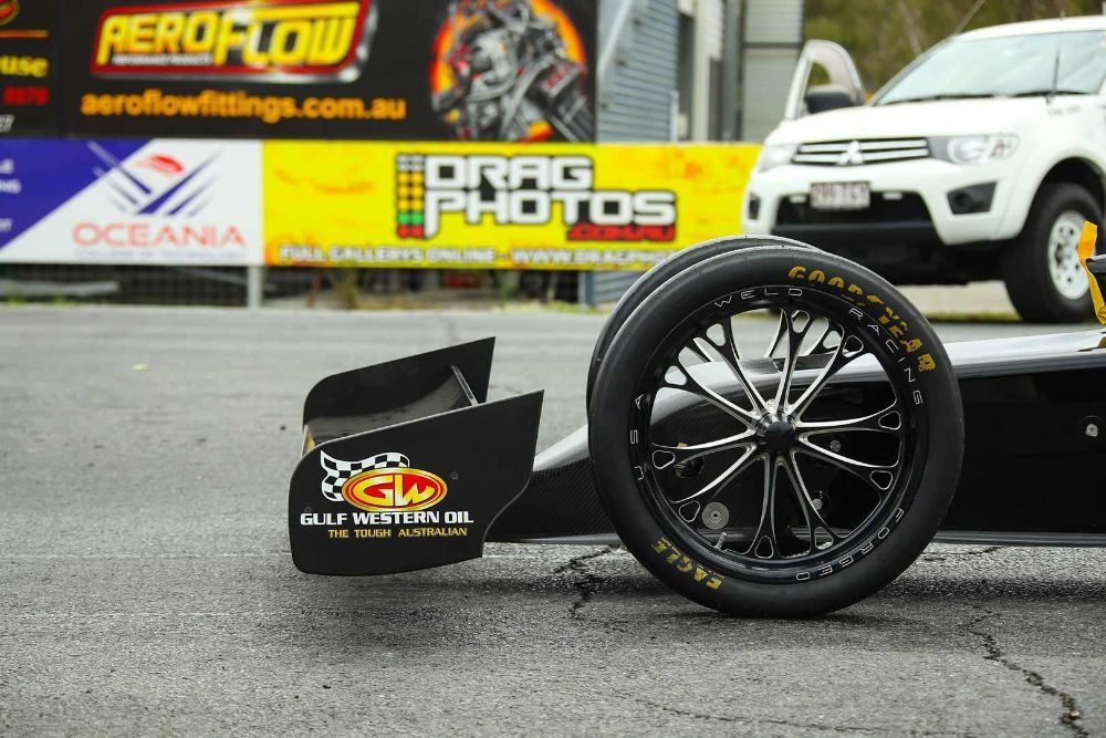 A Race Car Is Parked in Front of A Sign that Says Drag Photos — Wades Distributors In Mt Isa, QLD