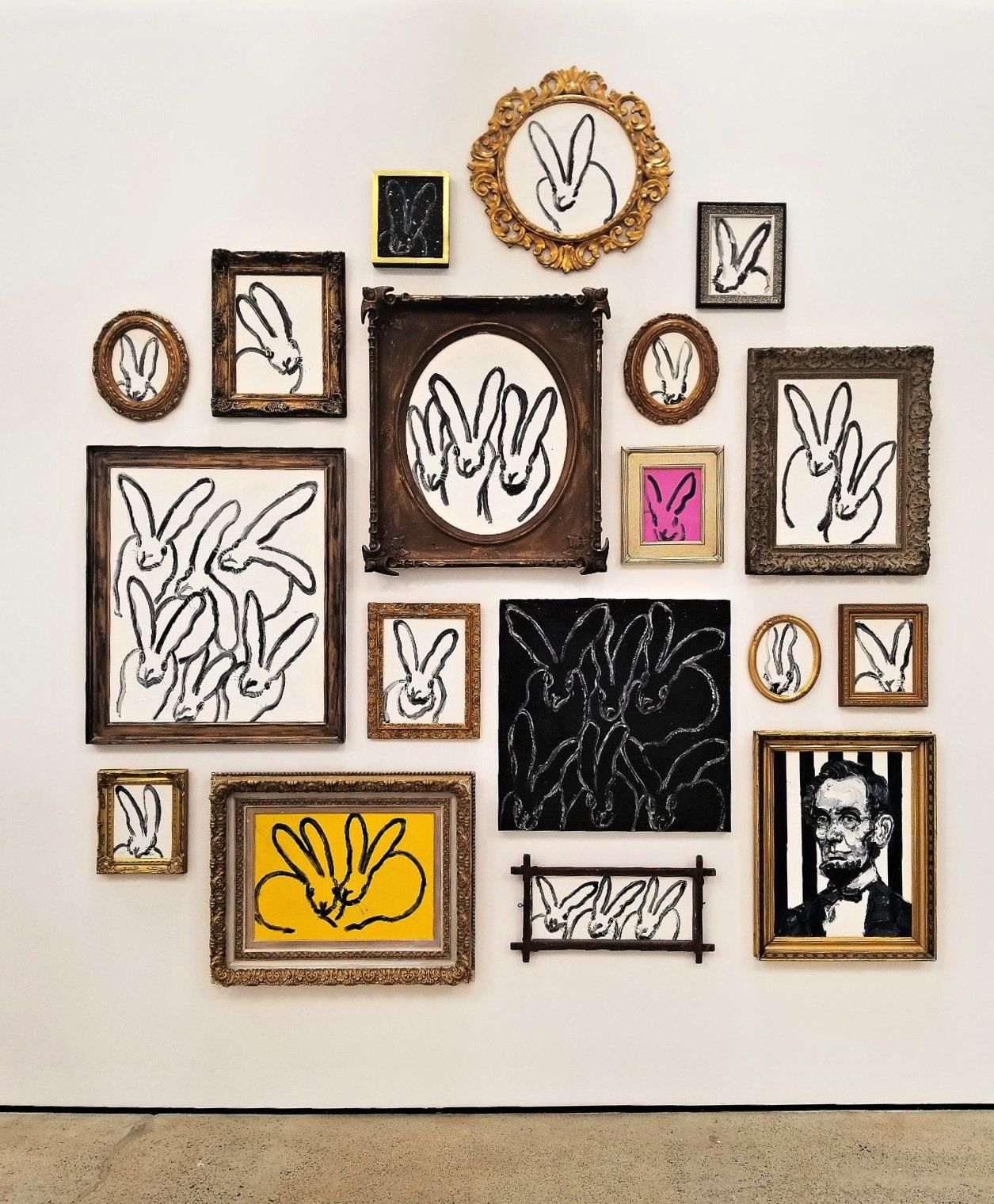 Art installation service in progress by skilled technicians in San Diego. Image of a wall with a bunch of framed pictures on it