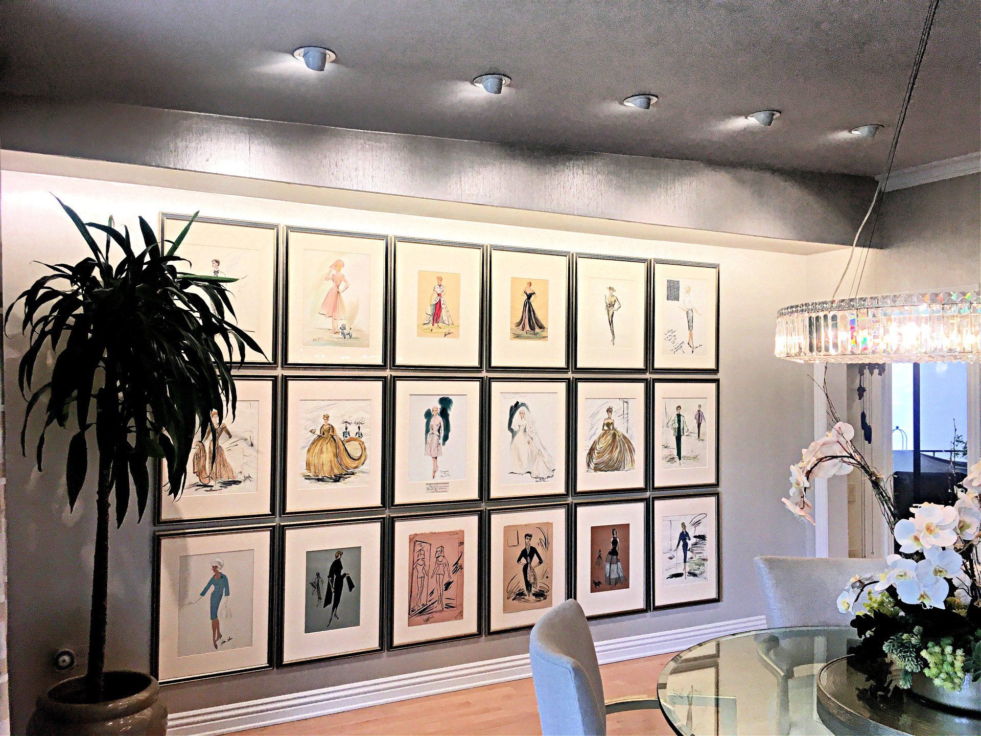 Art installation service in progress by skilled technicians in San Diego. Image of a dining room wall with perfectly placed framed pictures.