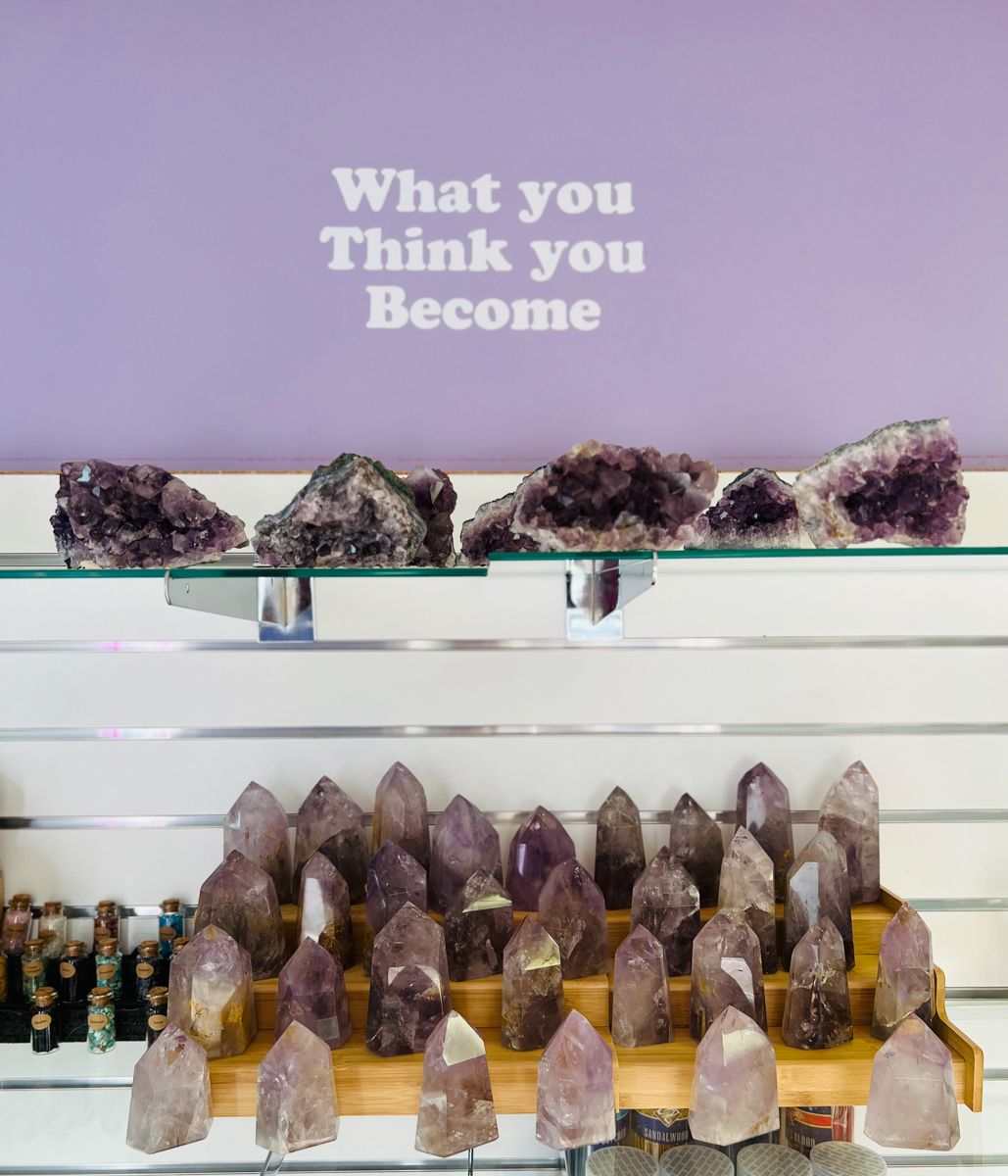 Shelf of amethyst crystals below a sign reading 
