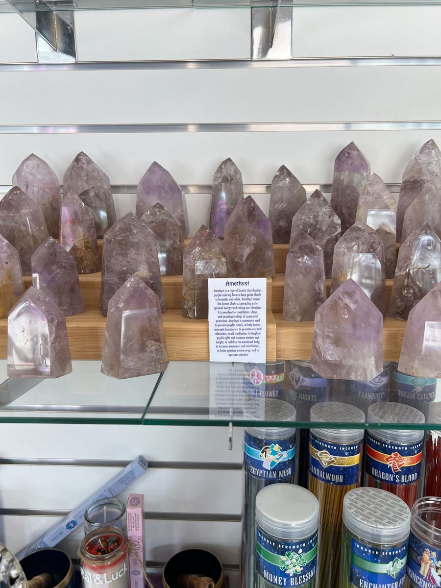 Amethyst crystal towers displayed on a shelf in a shop.