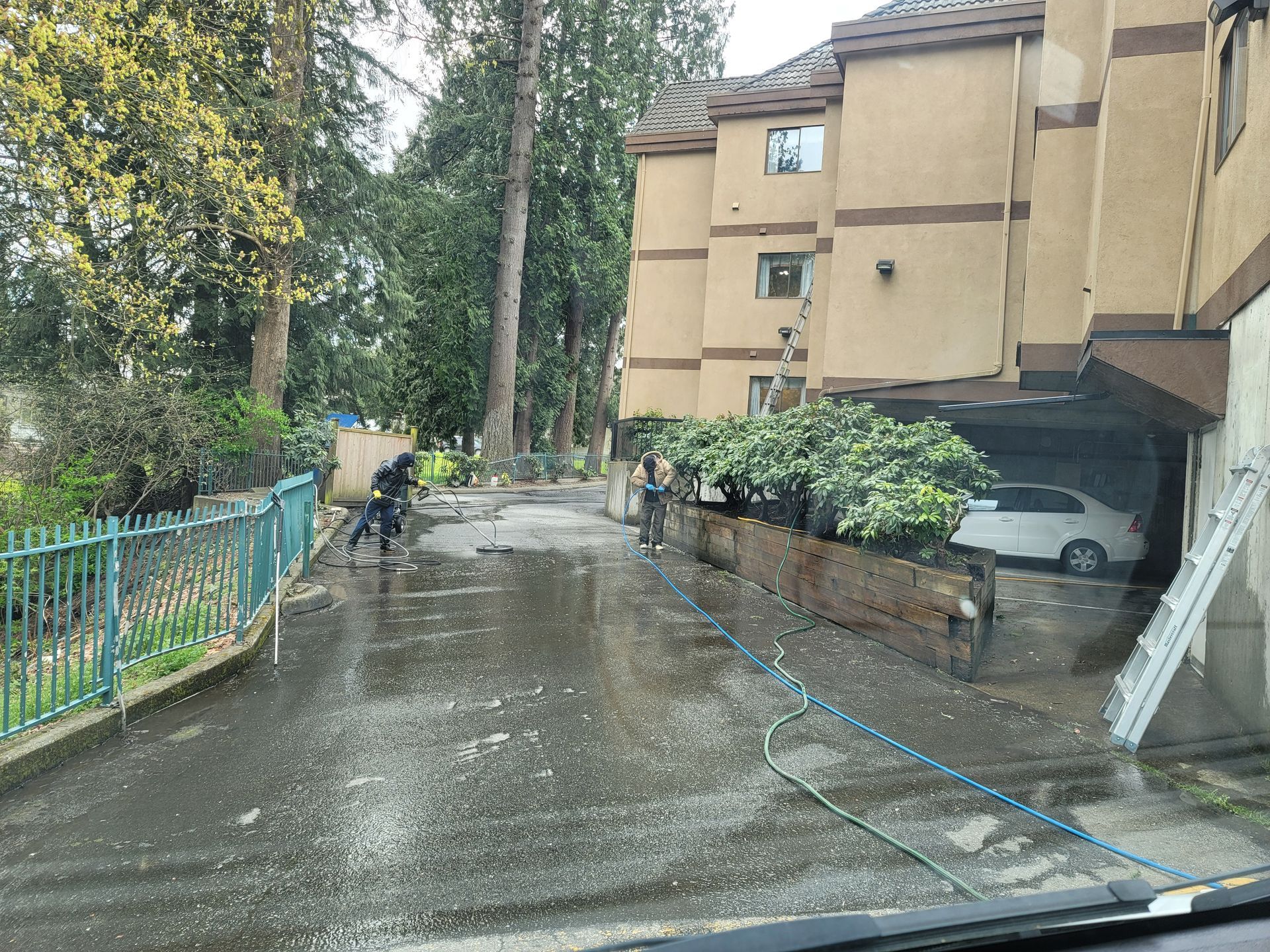 A car is parked in front of a building on a rainy day.