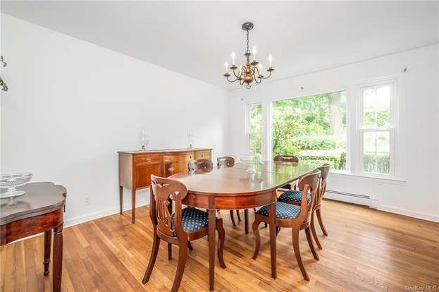 A dining room with a table and chairs and a chandelier.