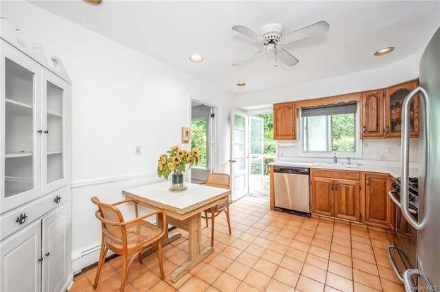 A kitchen with a table and chairs and a ceiling fan.