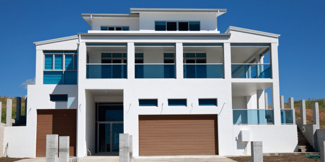 A large white house with a garage and balconies