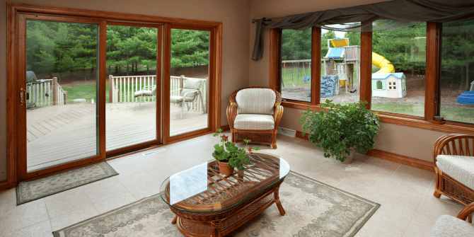 A living room with a table , chairs , and sliding glass doors leading to a deck.