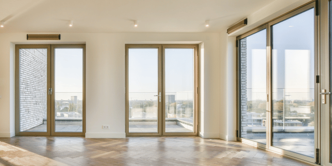 A large empty room with lots of windows and doors.