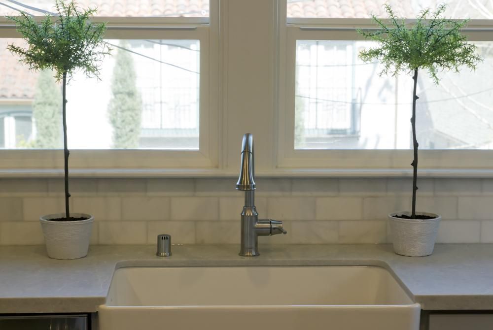 Farm kitchen with wide cream color apron-front basin sink.