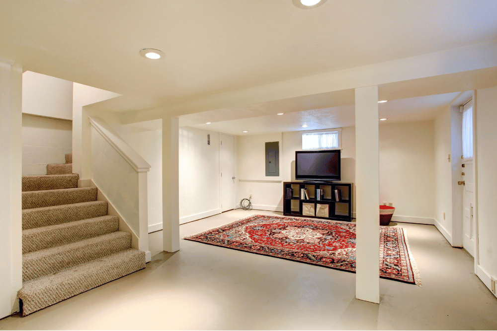 A basement with stairs and a flat screen tv