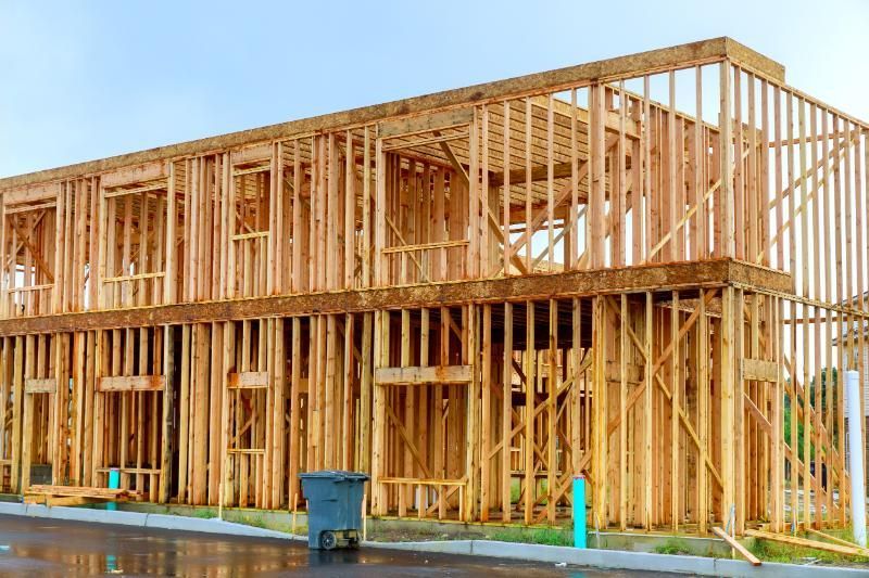 A large wooden house is being built on a construction site.