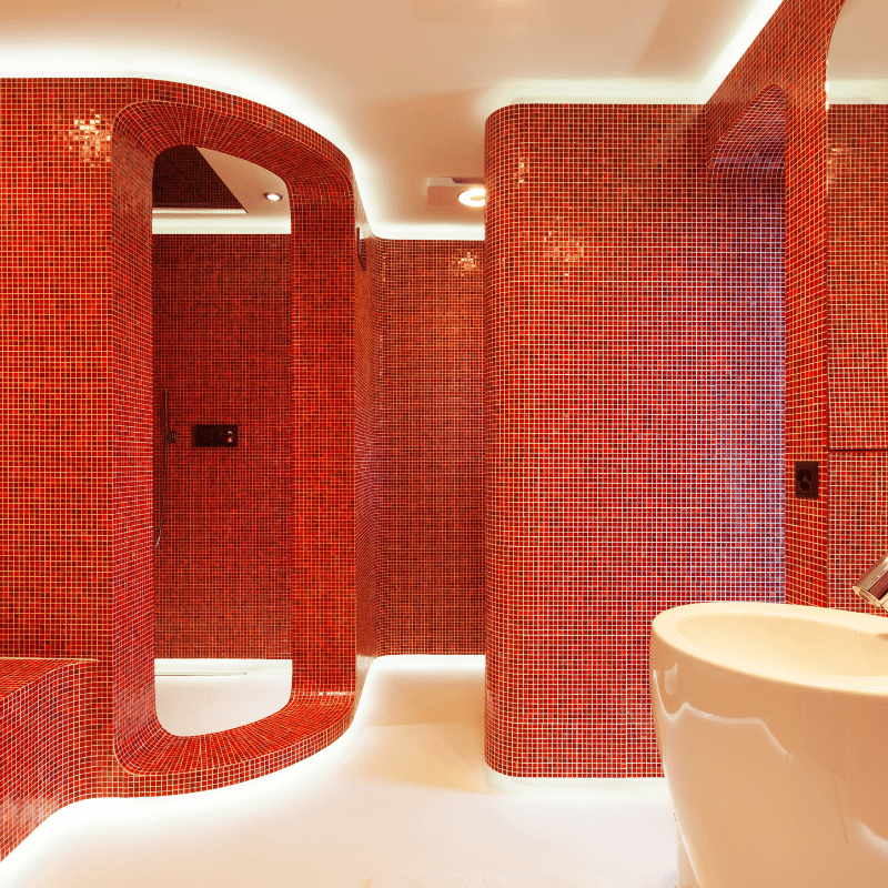 A bathroom with red tiles and a white sink