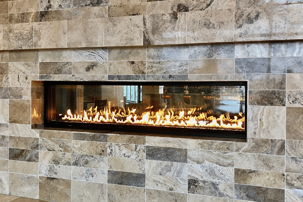 A fireplace is built into a tiled wall.