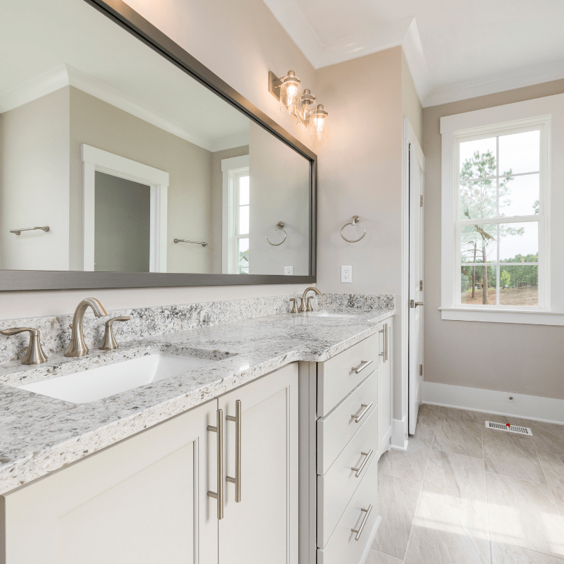 A bathroom with two sinks and a large mirror