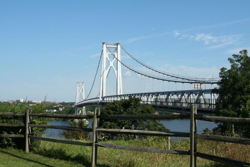 A bridge over a body of water with a wooden fence in the foreground